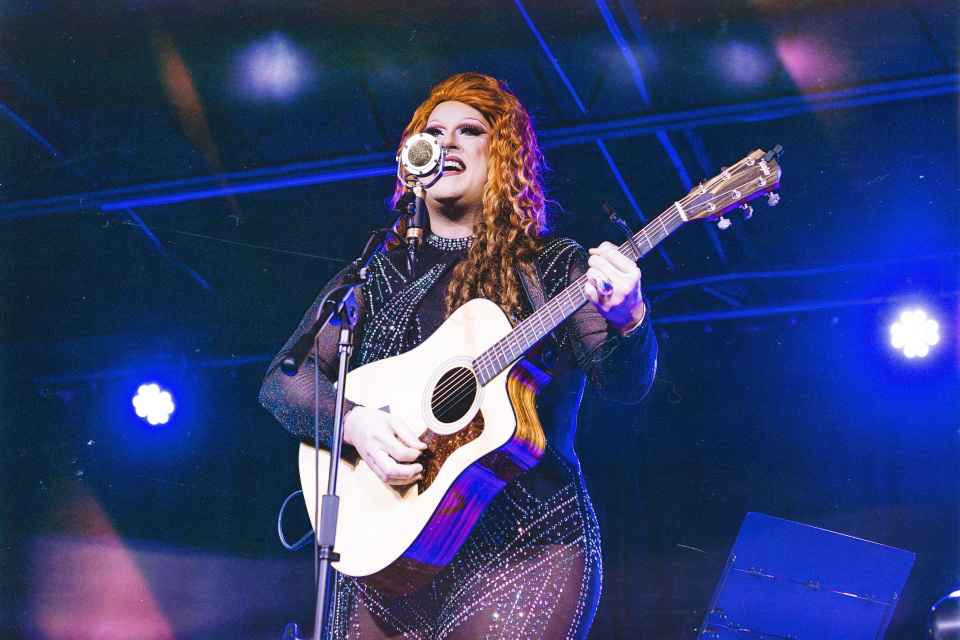 Photograph of Flamy Grant performing with a guitar and microphone